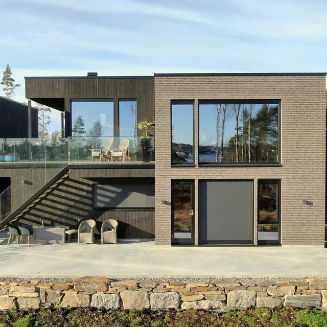 Moderne enebolig på to plan i stein og tre